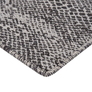 Close-up of houndstooth pattern on textured fabric, black and white.