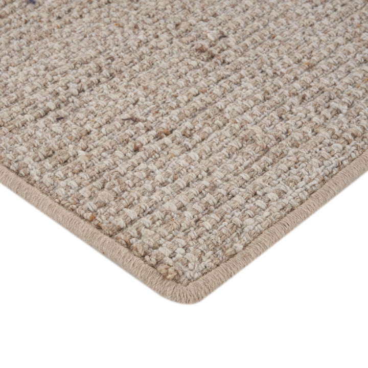 Close-up of loop pile textured carpet with bound edge detail.