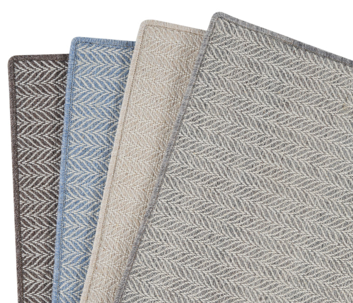 Four carpet samples with herringbone pattern in various colors displayed