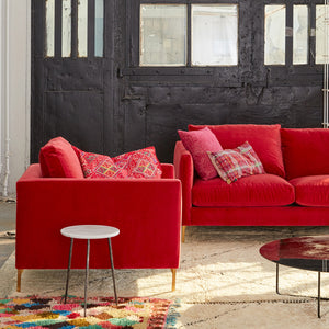 A purple two-seat sofa with sleek legs and slim track arms, upholstered in a velvet fabric. - hover