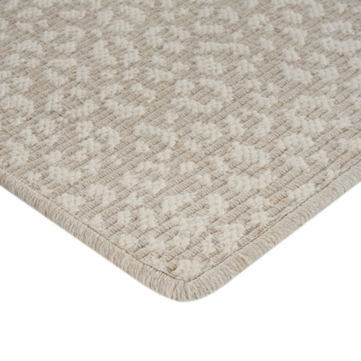 Close-up of cream textured rug with herringbone pattern and plush pile.