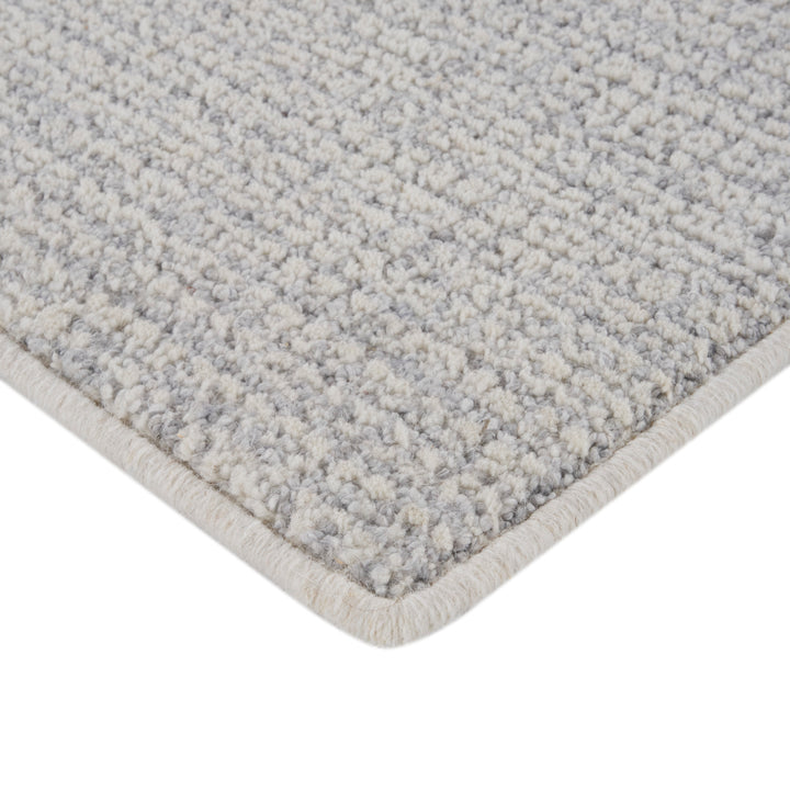 Close-up of plush gray carpet with neat binding edge detail.