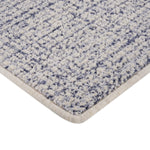 Close-up view of blue textured rug with plush tufted fibers.