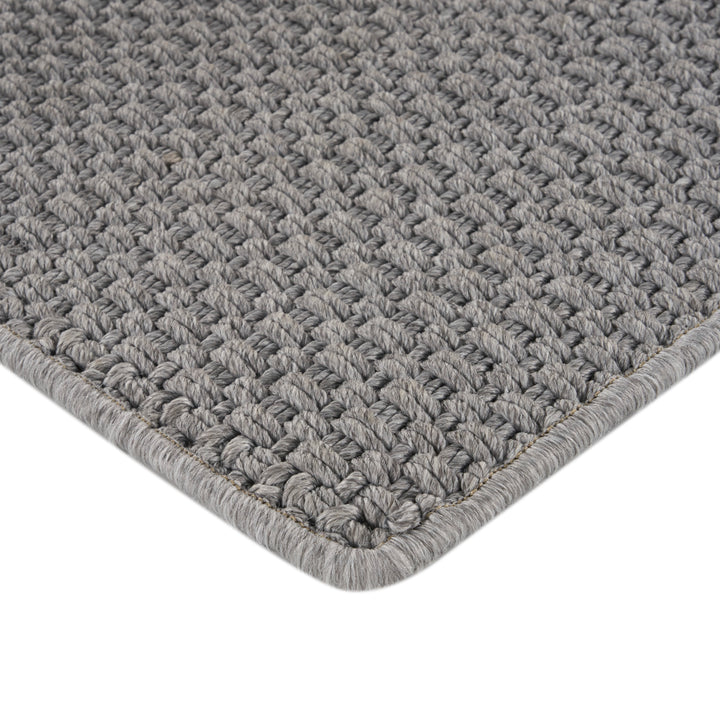 Close-up of grey woven rug with tight looped pile texture.