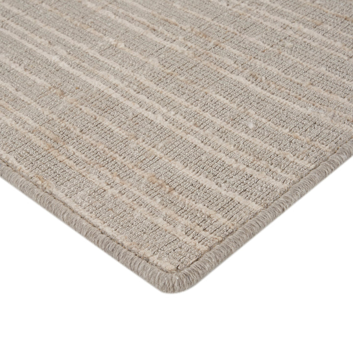 Close-up view of striped beige textured rug with dense weave.