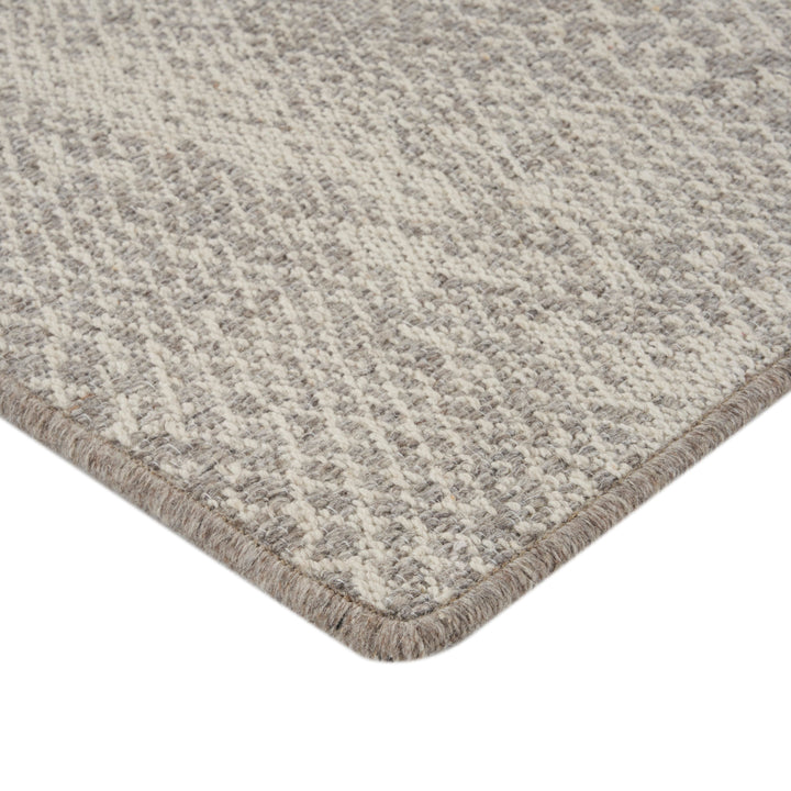 Close-up of textured beige rug with loop and cut pile.