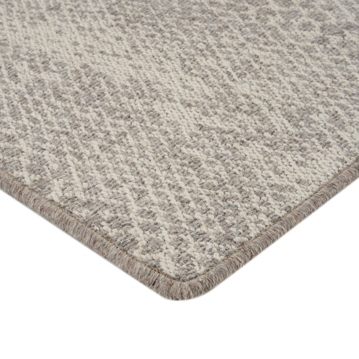 Close-up of textured beige rug with loop and cut pile.