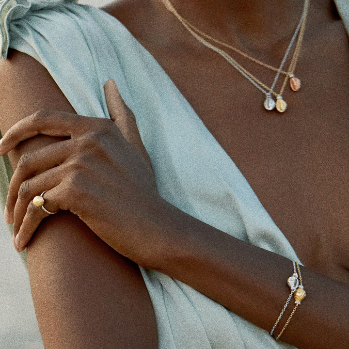 Elegant close-up shot of person adorned in delicate gold jewelry.