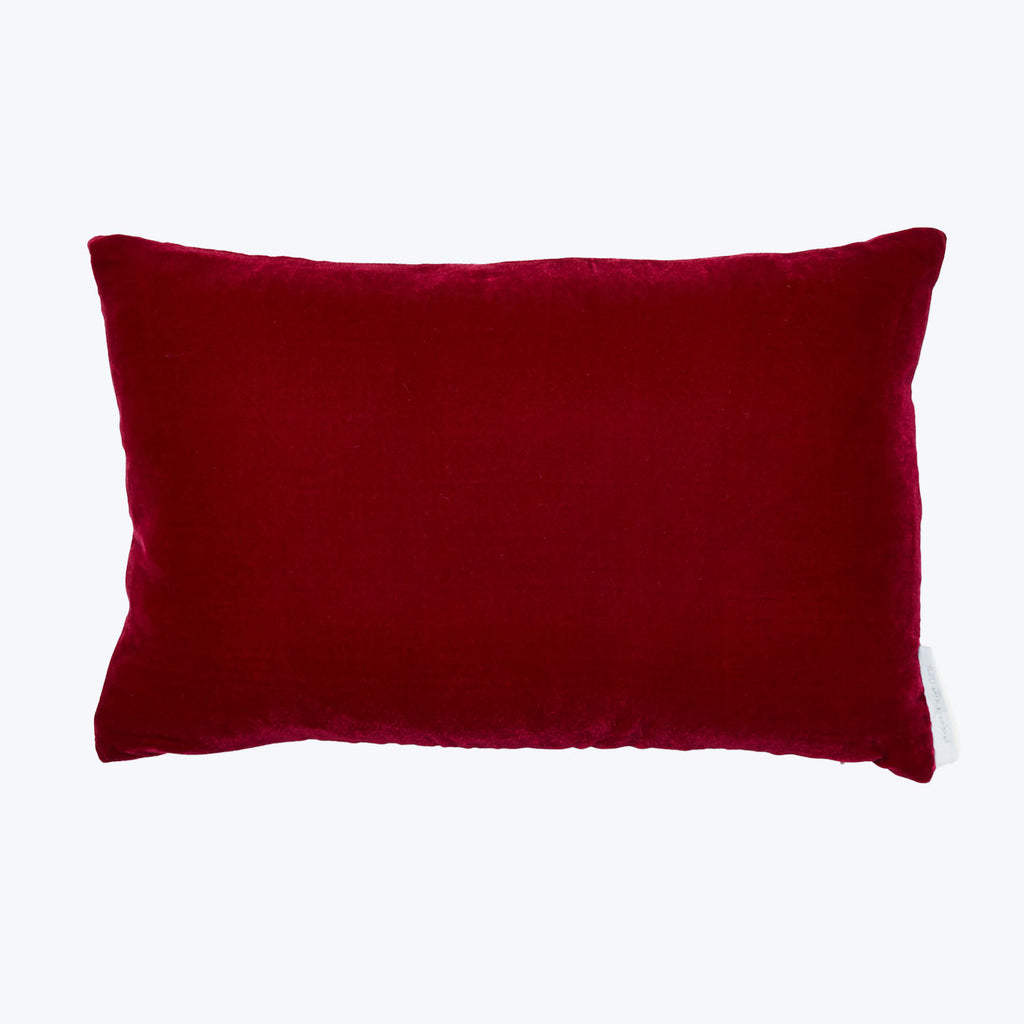 Rectangular dark red velvet pillow with rounded edges on white background.