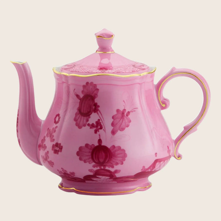 Pink teapot with floral design, gold trim, and elegant aesthetic.