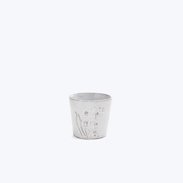 Rustic cup with plant relief design in light gray color.