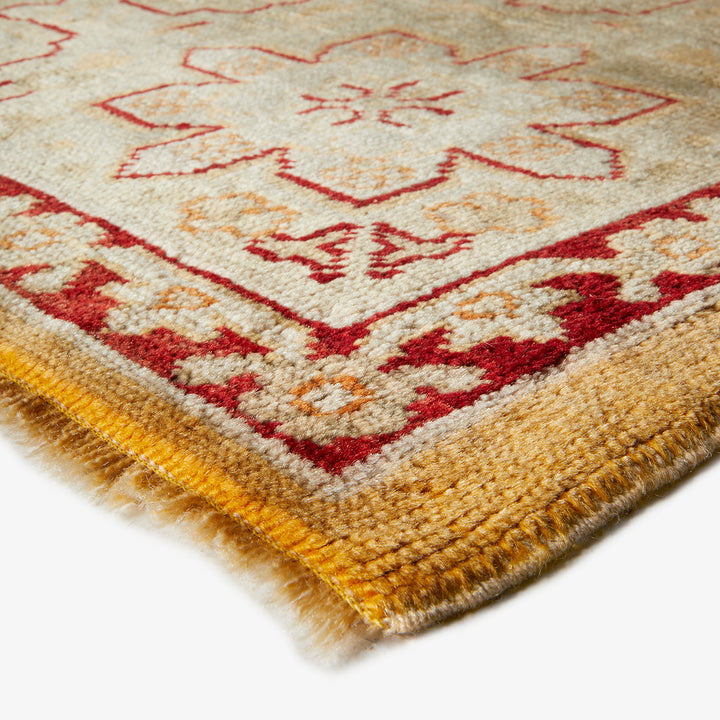 Close-up of a handcrafted, traditional rug with geometric motifs.