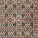 Intricate, stylized fabric pattern with symmetrical floral motifs in red and blue.