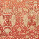 Antique rug with faded red pattern showcases intricate craftsmanship.