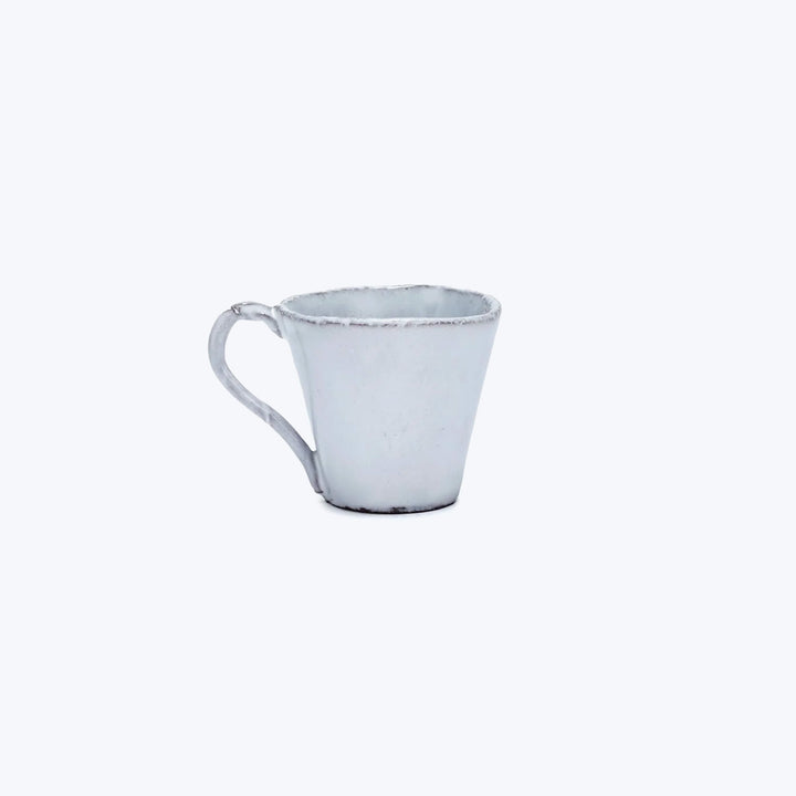 Minimalistic white ceramic cup on white background, rustic handmade design.