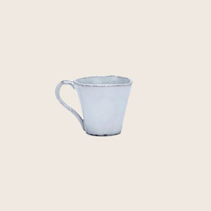 Minimalistic white ceramic cup on white background, rustic handmade design.