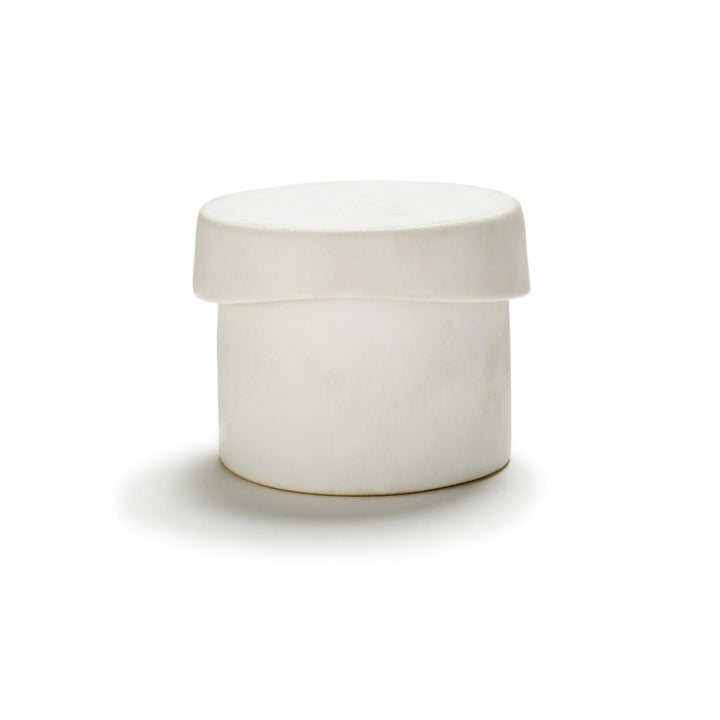 Minimalistic white container with secure lid, photographed on flat surface.