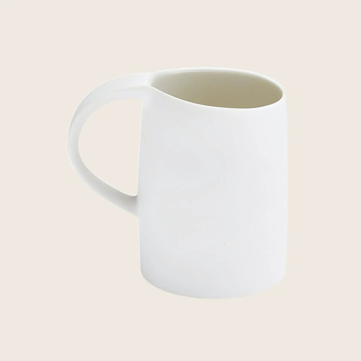 Minimalist white mug with sleek design and ergonomic handle.