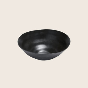 Minimalist black bowl with matte finish on white background.