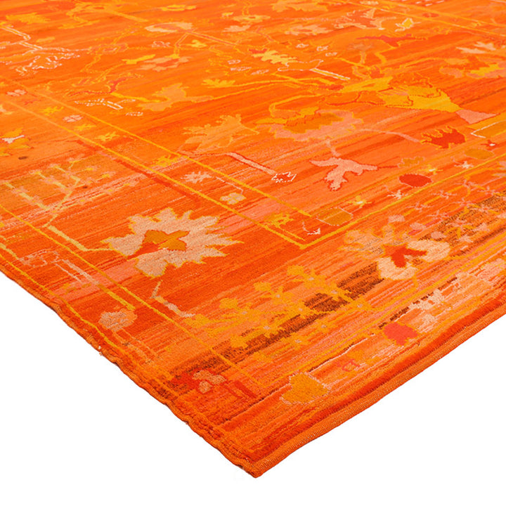 Close-up of vibrant orange rug with geometric and floral patterns.