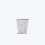 Embossed white cup with angelic figure design and floral patterns.