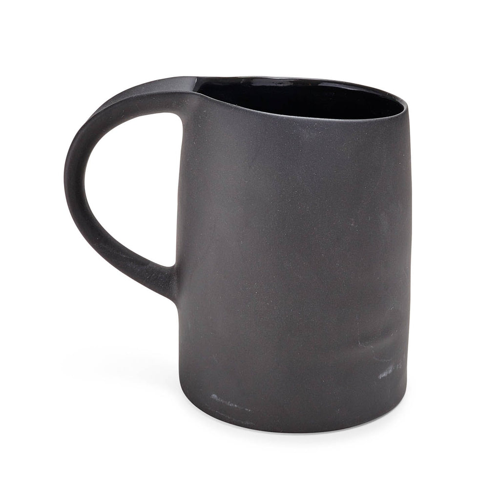 Matte black mug with shiny glazed interior on white background.