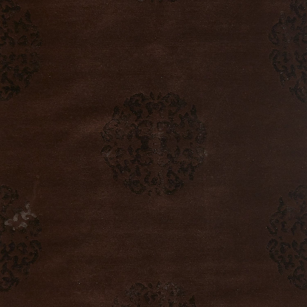 Close-up of a dark brown velvet fabric with ornate embossed patterns