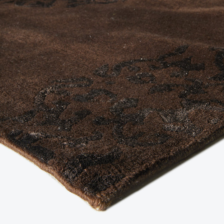 Ornate brown rug with plush texture and intricate black patterns
