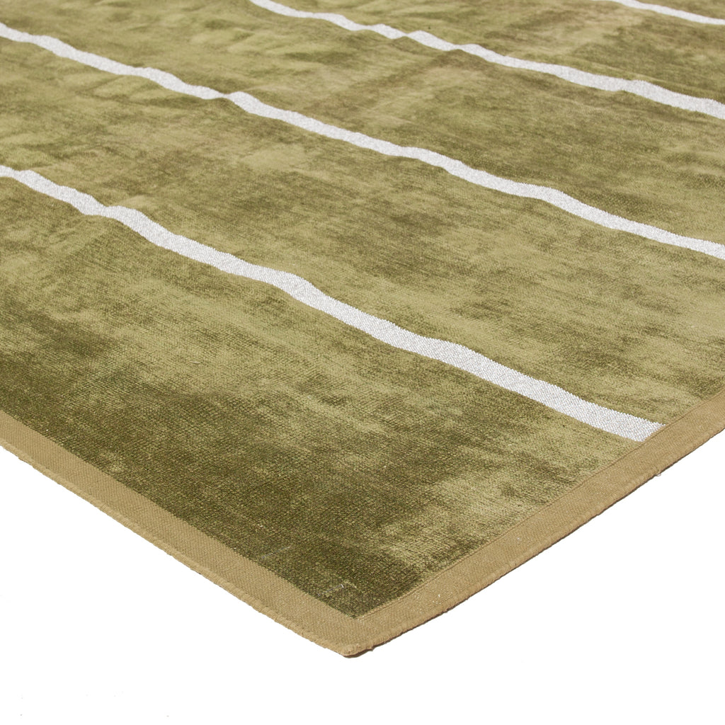 Close-up view of a thick olive green and white patterned rug.