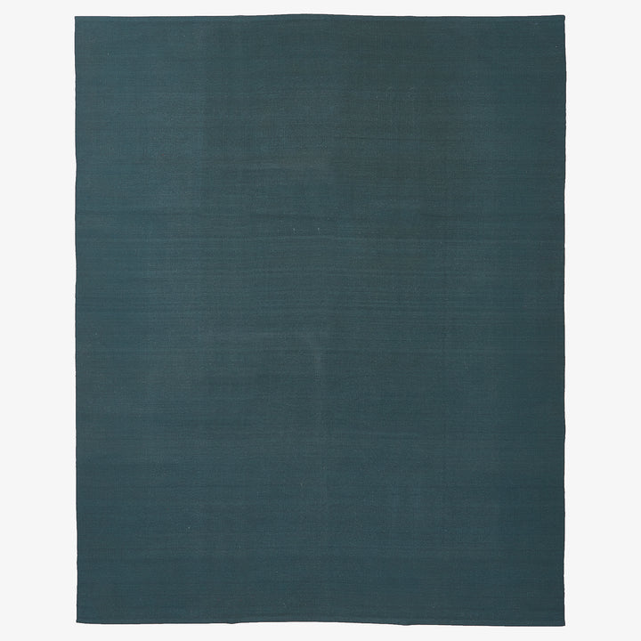 Minimalist textured surface in deep teal resembles textile or canvas.