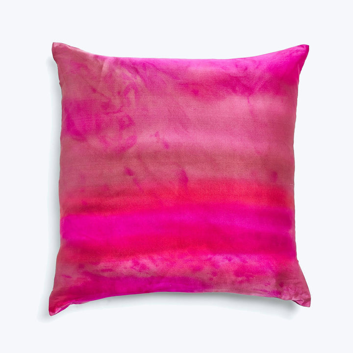 Vibrant pink and red watercolor effect pillow against white background.