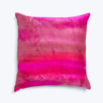 Vibrant pink and red watercolor effect pillow against white background.