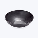 Simple black ceramic bowl on white background with textured pattern.