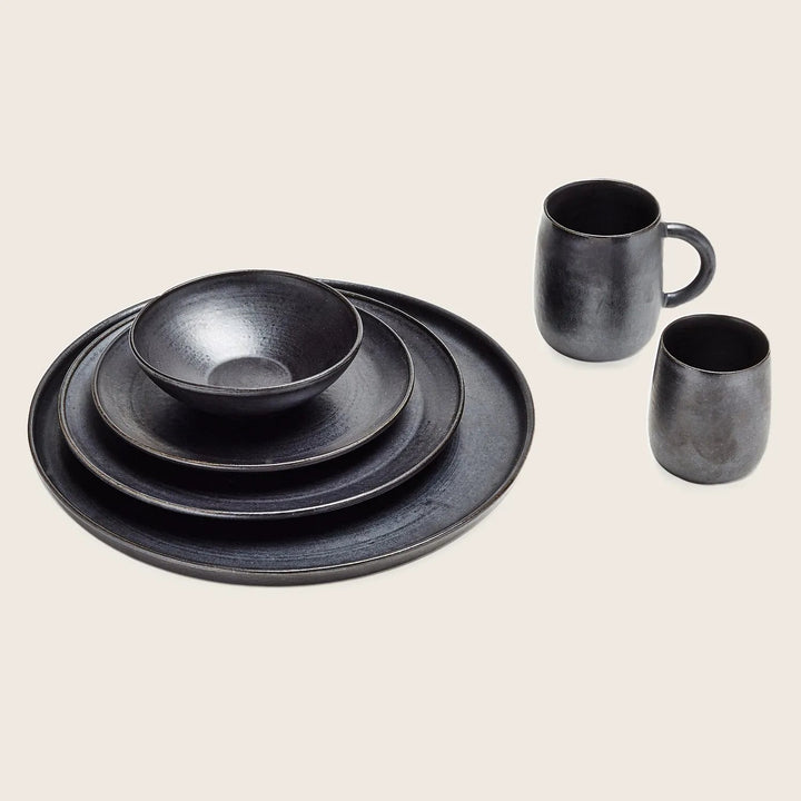 Graphite-colored dishware set on white background with rustic texture.
