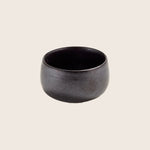 Minimalist black ceramic bowl with semi-matte finish on white background.