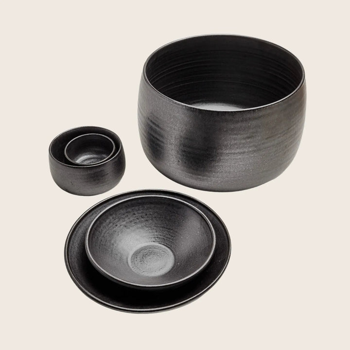 Handmade black ceramic tableware set with textured horizontal striations