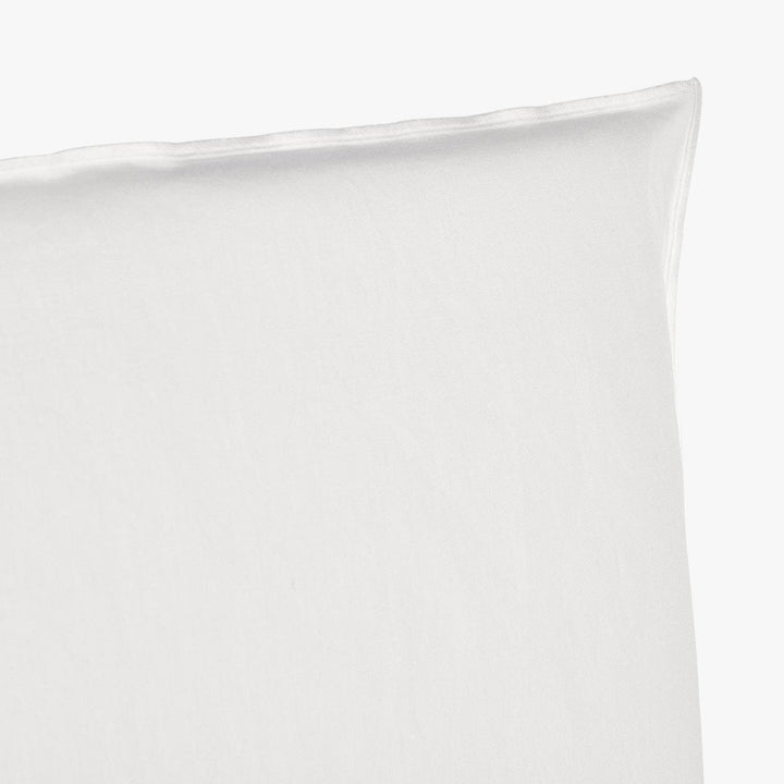 Close-up of a white pillow showcasing smooth texture and craftsmanship.