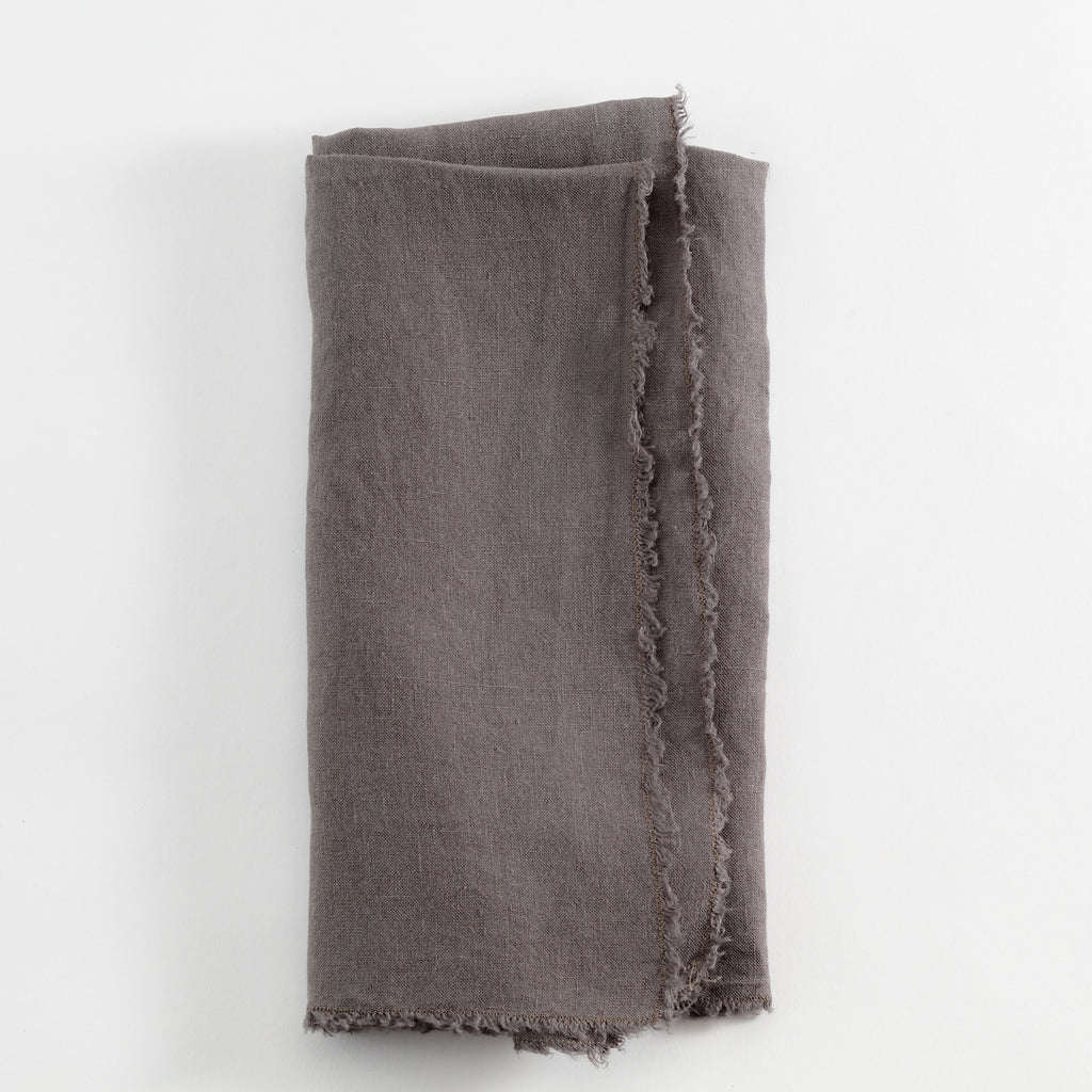 Folded textured fabric in muted gray shade with frayed edges.