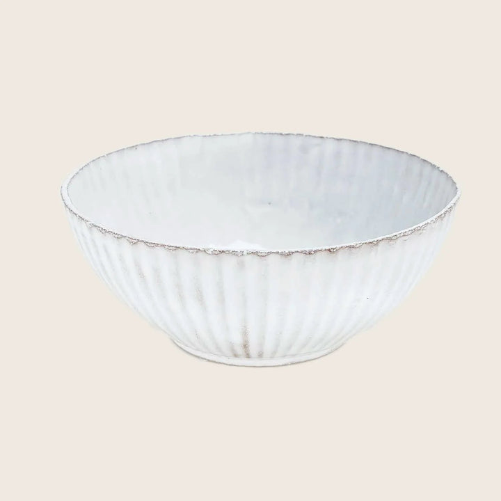 White ceramic bowl with textured exterior and rustic hand-crafted edge.