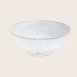 White ceramic bowl with textured exterior and rustic hand-crafted edge.