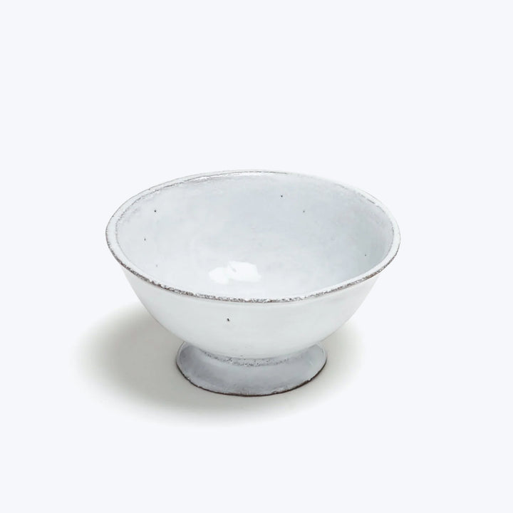 Simple ceramic bowl with distressed white glaze and footed base.