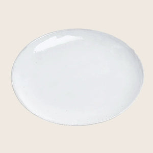 Handcrafted white ceramic dinner plate with rustic texture, empty background.