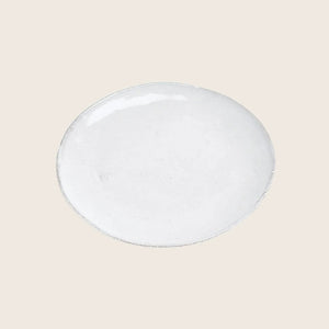 Handmade round ceramic plate with rustic design on white background.