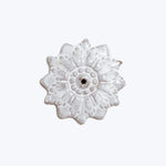 White glazed ceramic flower button with intricate petal details.