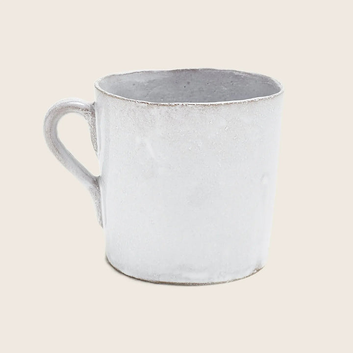Rustic white ceramic mug with worn rim embodies minimalist charm.