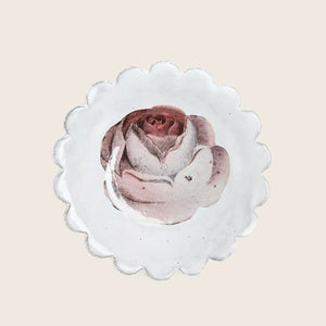 Detailed pink rose on scalloped paper, white background, artistic presentation.