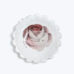 Detailed pink rose on scalloped paper, white background, artistic presentation.