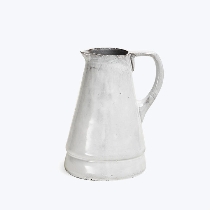 Vintage metal pitcher with classic design, slightly distressed, white background.