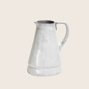 Vintage metal pitcher with classic design, slightly distressed, white background.