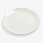 Plain white dinner plate with a glossy finish, photographed solo.